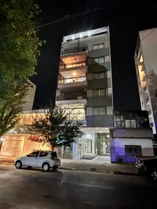 ein Auto, das nachts vor einem Gebäude parkt in der Unterkunft Apart in La Plata, elegante y equipado departamento in La Plata