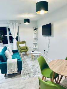 a living room with a blue couch and green chairs at Port of Dover Apartments in Kent