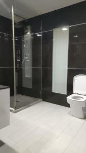een badkamer met een toilet en een glazen douche bij Mobilart in Oran