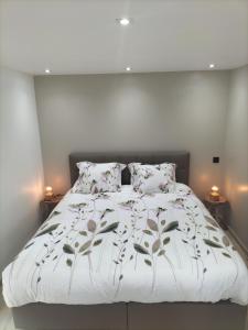 a bed with a white comforter and pillows at Trees Fontain in Jalhay