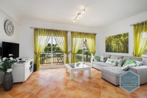a living room with a couch and a tv at Quinta do Paiva 10A Dream Lodging in Albufeira