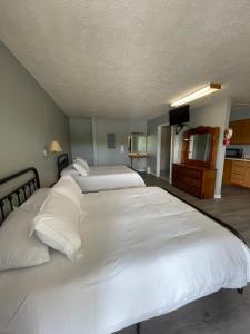 a bedroom with two white beds and a television at Moon River Marina & Resort in Cadiz