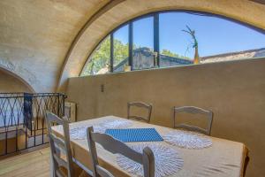 a dining room with a table and a large window at La Chapelle du Miracle in Avignon