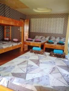 een woonkamer met een grote tegelvloer en bedden bij An Escape to a Semi-Countryside Retreat - SEE TOO VILLE- Nature Lodging Home in Sagada