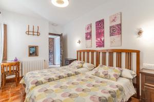 a bedroom with two beds and a table at El Secreto del Olivo in Nigüelas