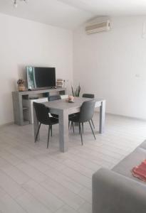 ein Esszimmer mit einem Tisch, Stühlen und einem TV in der Unterkunft Studio für 4 Personen ca 60 qm in Porto Torres, Sardinien Sassarese in Porto Torres