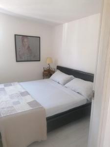 ein Schlafzimmer mit einem Bett und einem Bild an der Wand in der Unterkunft Studio für 4 Personen ca 60 qm in Porto Torres, Sardinien Sassarese in Porto Torres