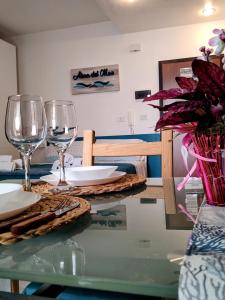 una mesa de cristal con copas de vino encima en Casa Alma del mar, en Montesilvano