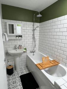 a bathroom with a bath tub and a sink at Grace House - 15 Minutes To Central London in Thamesmead