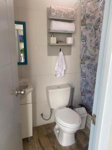 a bathroom with a toilet and a sink and towels at frente al mar San Bartolo in San Bartolo