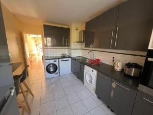 een keuken met een wasmachine en droger. bij Magnifique appartement de 90m2 dans une zone pavillonnaire d'Evry in Courcouronnes