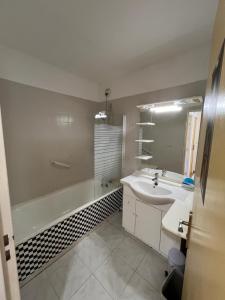 een badkamer met een wastafel, een bad en een wastafel bij Magnifique appartement de 90m2 dans une zone pavillonnaire d'Evry in Courcouronnes