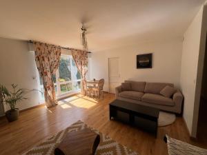 een woonkamer met een bank en een tafel bij Magnifique appartement de 90m2 dans une zone pavillonnaire d'Evry in Courcouronnes