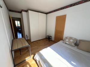 een slaapkamer met een bed en een tafel. bij Magnifique appartement de 90m2 dans une zone pavillonnaire d'Evry in Courcouronnes