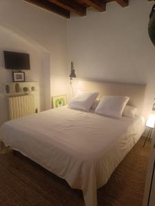 un grande letto bianco con cuscini bianchi in una camera da letto di Tortona Design Navigli Milan a Milano