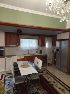 Apartment in quiet neighbourhood in Alimos في أثينا: مطبخ مع طاولة وكراسي ومطبخ مع