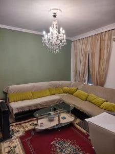 a living room with a couch and a chandelier at Apartment in quiet neighbourhood in Alimos in Athens