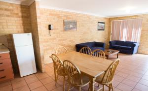 a kitchen and dining room with a table and chairs at Kalbarri Palm Resort in Kalbarri