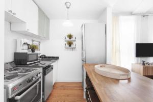 紐約的住宿－139-2E west village 1BR best value，厨房配有不锈钢冰箱和木制柜台。