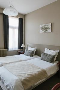 duas camas num quarto de hotel com lençóis brancos em Hotel Kempenrust em Kasterlee
