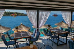 a view of the ocean from a restaurant with tables and chairs at Fabeno Villa in Sarandë