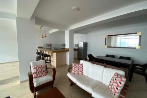 un soggiorno con divano e sedie e una cucina di Departamento de playa frente al mar a Cerro Azul
