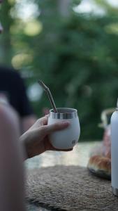 a hand holding a cup with a spoon in it at Complejo Enrique Joaquin in Mercedes