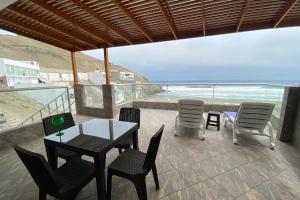 d'un balcon avec une table et des chaises donnant sur l'océan. dans l'établissement Departamento de playa frente al mar, à Cerro Azul