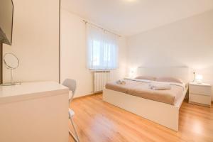 a white bedroom with a bed and a mirror at Ferienwohnung für 5 Personen ca 75 qm in Pula-Fondole, Istrien Istrische Riviera in Veli Vrh