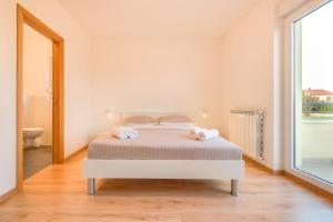 a white bedroom with a bed and a bathroom at Ferienwohnung für 5 Personen ca 75 qm in Pula-Fondole, Istrien Istrische Riviera in Veli Vrh