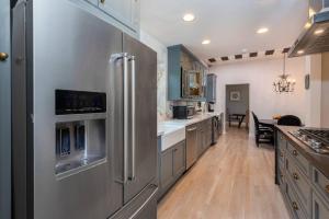 a large kitchen with stainless steel appliances and wooden floors at Luxurious Living: Modern 5BR Home, LA's Best Stay! in Los Angeles