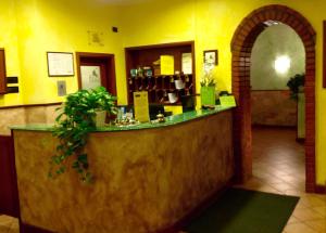 a restaurant with a counter in a yellow room at Hotel Toscana in Prato