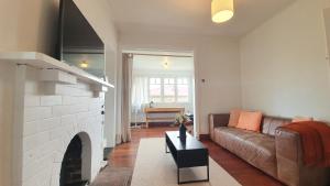 a living room with a couch and a fireplace at Kingsland Family Home in Auckland