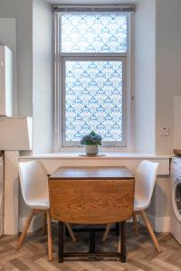 Thistle do Nessly في إينفيرنيس: طاولة وكراسي في مطبخ مع نافذة