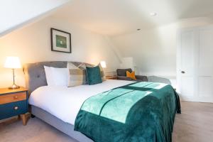 Thistle do Nessly في إينفيرنيس: غرفة نوم مع سرير مع بطانية خضراء عليه