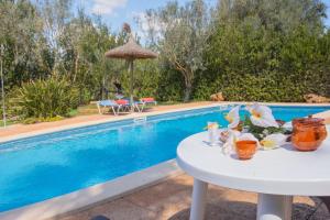 una mesa con flores junto a una piscina en Ferienhaus mit Privatpool für 5 Personen ca 85 qm in Campos, Mallorca Südküste von Mallorca, en Campos