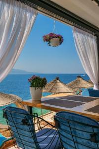 a table and chairs with a view of the ocean at Fabeno Villa in Sarandë