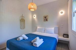 um quarto com uma cama azul com toalhas em Molos Beachfront Apartments in Diakopto em Diakopto