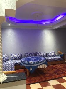 een woonkamer met banken en een paars plafond bij Dar zahra in Aourir