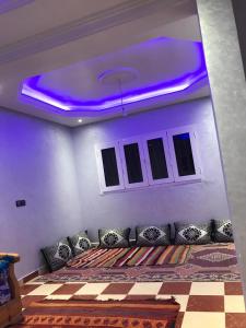 een kamer met een bank en een paars plafond bij Dar zahra in Aourir