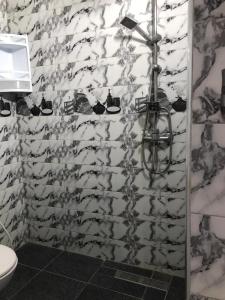 a bathroom with a shower with black and white tiles at Dar zahra in Aourir
