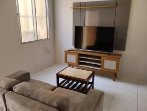 a living room with a couch and a flat screen tv at Andre's Home casa M in Governador Valadares