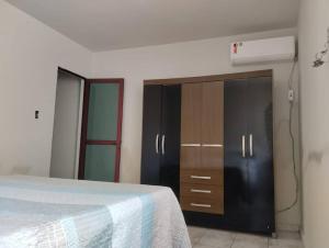 a bedroom with a bed and a dresser at Andre's Home casa M in Governador Valadares