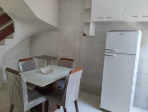 uma cozinha com uma mesa e cadeiras e um frigorífico em Andre's Home casa M em Governador Valadares