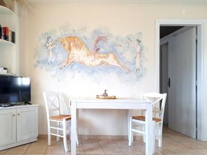 a dining room with a white table and a painting of a horse at Sirens Villas - Sea View Private Pool Villas in Skopelos Town