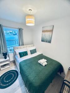 a bedroom with a large bed with a green blanket at Dover Castle Luxury Apartments in Kent