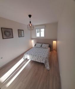 a white bedroom with a bed and a window at Chez Lydia et Cédric in Rochefort-du-Gard