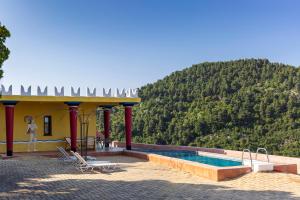 a house with a swimming pool in front of a mountain at Sirens Villas in Skopelos Town