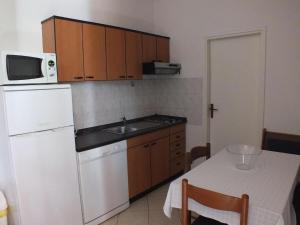 a small kitchen with a white refrigerator and a table at Ferienwohnung für 4 Personen 2 Kinder ca 52 m in Fiorini, Istrien Umag und Umgebung in Fiorini