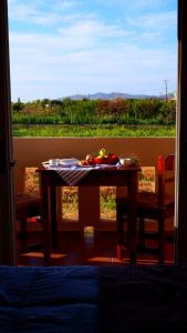 une table avec une plaque de fruits devant une fenêtre dans l'établissement Kamara Apartments Marmari, à Marmari